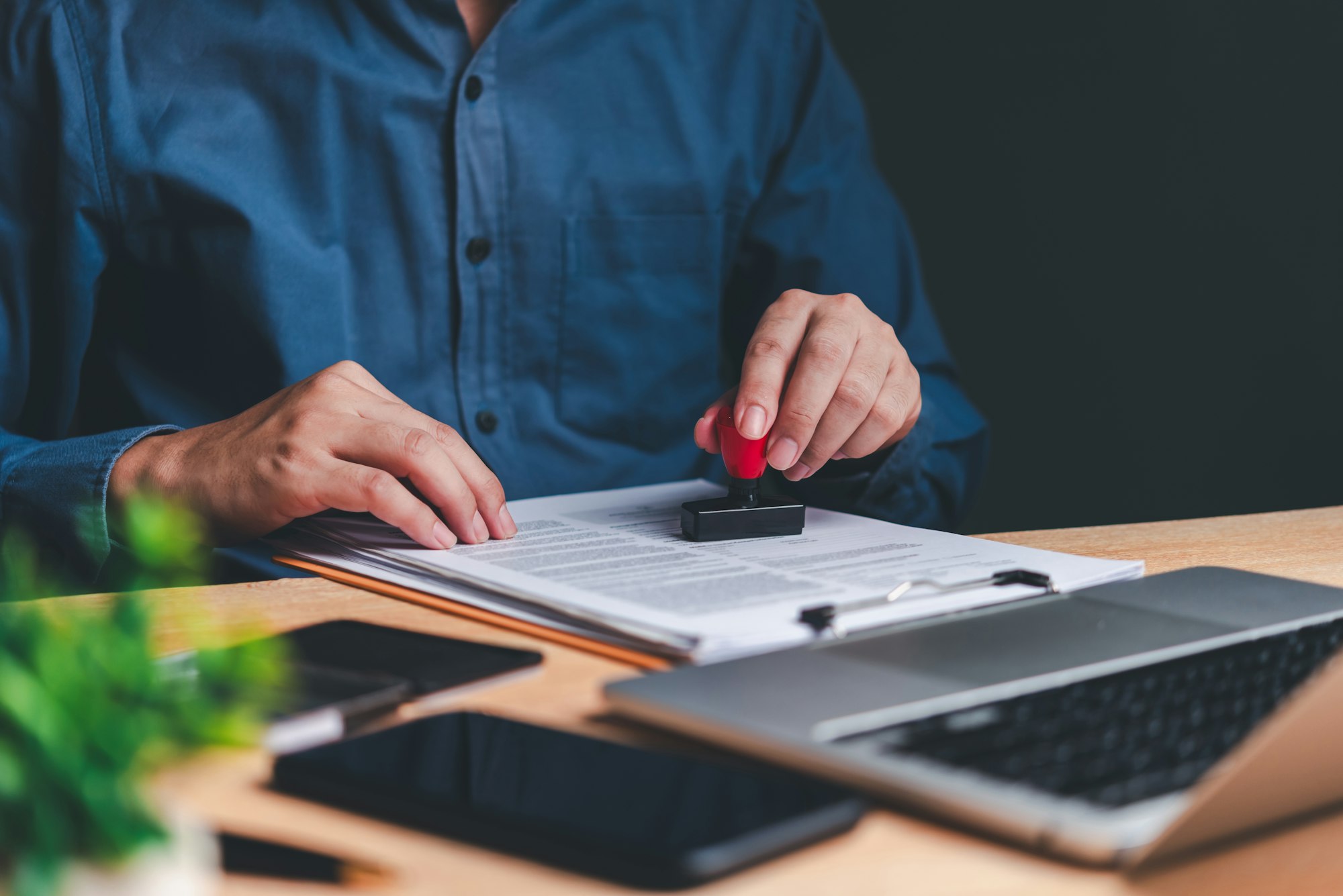 A person's hands are seen stamping a document